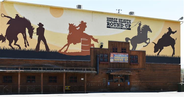 A colorful mural featuring cowboys on horseback