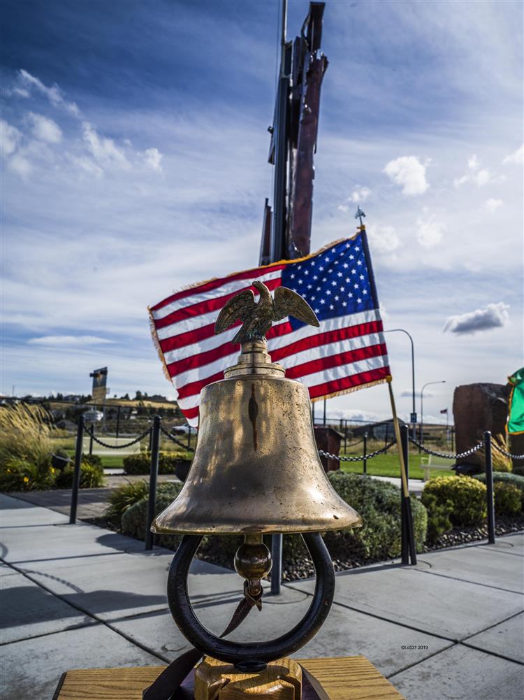 A low-angle shot of a brass bell with an eagle figurine atop it